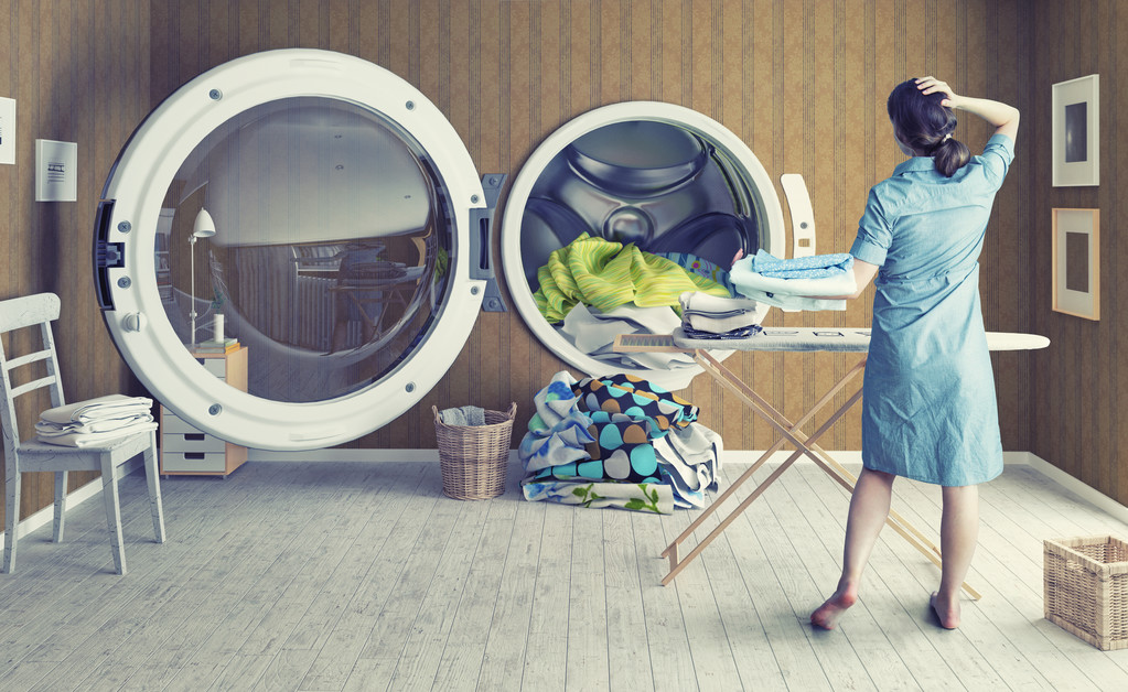 Jeune femme confuse devant un lave-linge
